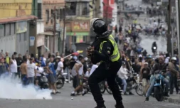 Un policier anti-émeutes tire du gaz lacrymogène contre des manifestants opposés au président Nicolas Maduro, dans le quartier de Catia à Caracas le 29 juillet 2024 ( AFP / Yuri CORTEZ )