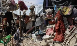 Des jouets ayant appartenu aux enfants du Palestinien Wissam Wishah – Saïd, Salma et Eline –, tués lors de bombardements israéliens, sont suspendus à une corde à linge sur les décombres de leur maison, dans le camp de réfugiés d’Al-Bureij, dans le centre de la bande de Gaza, le 1ᵉʳ mai 2025. EYAD BABA / AFP 
