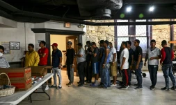 Des migrants font la queue pour une distribution de repas dans un refuge à San Antonio, le 29 juin 2022 au Texas