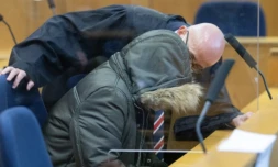 Alaa Moussa (G), un médecin syrien accusé de crimes contre l'humanité, parle avec son avocat à l'ouverture de son procès, le 19 janvier 2022 à Francfort ( POOL / Boris Roessler )