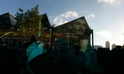 Un migrant regarde à travers la vitre du bus qui l'évacue du camp de migrants installé à la halle Pajol, le 29 juin 2016 à Paris