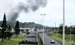 Des fumées à distance avec des barricades sur la route dans le quartier Montravel de Nouméa, le 21 mai 2024 en Nouvelle-Calédonie ( AFP / Theo Rouby )