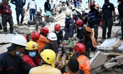 Des membres de la protection civile vénézuélienne et des pompiers sortent un jeune homme des décombres d'un immeuble effondré à Catia La Mar, dans l'Etat de La Guaira, au Venezuela, le 26 juin 2026 ( AFP / Federico PARRA )