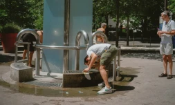 Des parisiens se rafraichissent et remplissent leurs bouteilles d'eau à la fontaine de la Butte aux Cailles, le 21 juin 2026. (JUDITH CRICO / HANS LUCAS / AFP)