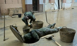 Des soldats évacuent la boue d'un égout à Paiporta, au sud de Valence, dans l'est de l'Espagne, le 13 novembre 2024, à la suite d'inondations meurtriÚres