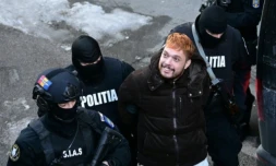 Mohamed Amra escorté par des policiers, le lendemain de son arrestation à Bucarest le 23 février 2025 ( AFP / Daniel MIHAILESCU )