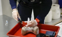 Un douanier contrôle un paquet de cocaïne à l'aéroport d'Orly, au sud de Paris, le 7 novembre 2022 ( AFP / Geoffroy Van der Hasselt )