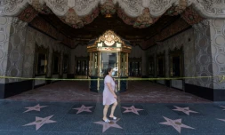 Une femme marche devant le fameux cinéma El Capitan à Hollwood, fermé à cause du coronavirus, à Los Angeles, le 12 juin 2020