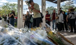 Des personnes se rassemblent le 29 novembre 2025 pour déposer des fleurs devant le complexe résidentiel de Wang Fuk Court à Hong Kong à la suite de l’incendie meurtrier survenu trois jours auparavant