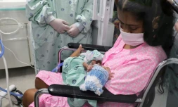 Diana Angola, atteinte par le coronavirus, tient dans ses bras son fils Jefferson Ă la clinique de Versalles, le 23 juin 2020 Ă Cali, en Colombie