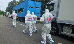Cette photographie, prise et publiée par le Siège de coordination pour le traitement des prisonniers de guerre le 11 juin 2025, montrerait des représentants de la Croix-Rouge internationale passant devant le cortège de réfrigérateurs du convoi transportant les corps de soldats ukrainiens, au milieu de l'invasion russe en Ukraine. -  Coordinating Headquarters for the Treatment of Prisoners of War / AFP