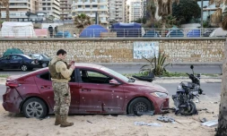 Un soldat inspecte un véhicule endommagé sur le site d'une frappe aérienne israélienne dans la zone côtière de Ramlet al-Bayda à Beyrouth, le 12 mars 2026 au Liban