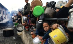 Des Palestiniens attendent avec des récipients pour recevoir de la nourriture dans un camp de réfugiés à Rafah, dans le sud de la bande de Gaza, le 23 décembre 2023