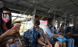Les passagers d'un bus portant masque et écran facial dans un bus à Manille le 8 septembre 2020