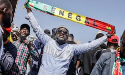 Un homme brandit une banderole lors d'une manifestation contre le report de la présidentielle au Sénégal, à Dakar le 17 février 2024
