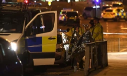 Des spectateurs près d'une salle de concerts à Manchester le 23 mai 2017, où une possible attaque terroriste a fait 19 morts et une cinquantaine de blessés