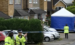 Des policiers devant une tente d'équipe médico-légale à Ashley Close à Bushey dans le Hertfordshire, au nord de Londres, le 10 juillet 2024, aprÚs un triple meurtre ( AFP / JUSTIN TALLIS )
