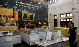 Une proche de défunt pleure devant les cercueils des victimes du naufrage d'un bateau de tourisme dans la baie d'Halong, le 20 juillet 2025 à Halong