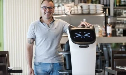 Geoffrey Ruamps, directeur du restaurant le Cap 180, pose avec le robot serveur "Bella" dans son restaurant, Ă Cieurac, dans le Lot, le 14 mai 2024 AFP / Matthieu RONDEL