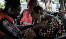 Un membre de la Croix-Rouge réconforte un fidÚle de l'Eglise Internationale de Bonne Nouvelle secouru, prÚs de la ville cotiÚre de Malindi,le 25 avril 2023 au Kenya ( AFP / Yasuyoshi CHIBA )