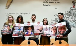 Des proches d'otages avec les photos des victimes, à droite le frère d'Elya Toledano, avec la photo d'Elya, à Paris le 31 octobre 2023