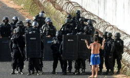 La police anti-émeute s'approche d'un homme choisi pour négocier au nom des détenus en rebélion au centre pénitentier d'Alcacuz dans l'Etat de Rio Grande do Norte dans le nord-est du Brésil, le 16 janvier 2017