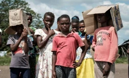 Des enfants assistent le 26 mars 2019 à une distribution d'aide dans la zone d'Estaquinha, au Mozambique, frappée par le cyclone Idai.