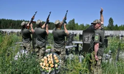 Des soldats ukrainiens honorent l'un des leurs par une salve lors de ses funérailles au cimetière de Boutcha, près de Kiev, le 20 juin 2022