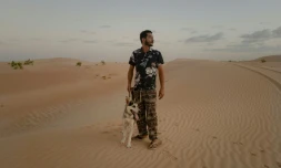 Ahmed Maham et son chien husky sibérien Kayo dans les dunes de Nouakchott, en Mauritanie, le 9 octobre 2024