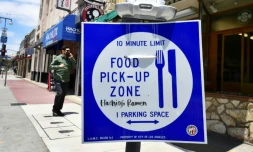 Un panneau devant un restaurant vendant de la nourriture Ă emporter aprĂšs la fermeture des salles de restaurant, Ă Los Angeles le 1er juillet 2020