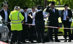 Des habitants derrière un périmètre de sécurité établi dans le quartier de Golders Green, au nord de Londres, le 29 avril 2026, après l'agression au couteau de deux personnes