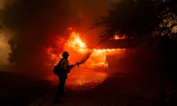 Un pompier lutte contre les flammes du "Mountain Fire", qui engloutissent une maison près de Camarillo, en Californie, le 6 novembre 2024