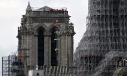 La croix de Notre-Dame de Paris soulevĂ©e par une grue pour ĂȘtre placĂ©e au sommet de la flĂšche de la cathĂ©drale, le 6 dĂ©cembre 2023, Ă Paris ( AFP / Miguel MEDINA )