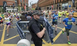 Un policier en armes surveille le déroulement du semi-marathon de Manchester, le 28 mai 2017