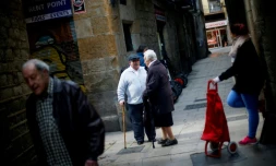 Le retraité Manuel Mourelo Gonzalez (c) discutent avec ses voisins dans le centre de Barcelone, en Espagne, le 17 février 2017