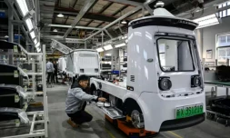 Des ouvriers travaillent sur une ligne de production de l'usine Neolix qui fabrique de petits véhicules utilitaires autonomes pour le transport de colis en ville, le 4 décembre 2025 à Yancheng dans la province chinoise du Jiangsu ( AFP / Jade GAO )