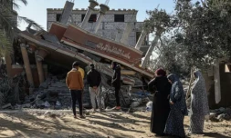Des Palestiniens se tiennent devant les décombres d'une maison détruite par une frappe israélienne sur Khan Younès, dans le sud de la bande de Gaza, le 5 mars 2024 ( AFP / SAID KHATIB )