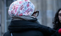 L'infirmière Majdouline, révoquée de la fonction publique pour avoir pour avoir refusé de manière répétée d'ôter son calot chirurgical, s'adresse aux journalistes devant le tribunal administratif de Paris, le 23 décembre 2025 ( AFP / BERTRAND GUAY )