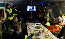 Des gilets jaunes regardent l'allocution télévisée d'Emmanuel Macron dans un restaurant à Fay-aux-Loges, le 10 décembre 2018