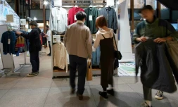 Des clients regardent des articles de seconde main de la marque japonaise Uniqlo vendus dans un pop-up store, le 17 octobre 2023 à Tokyo
