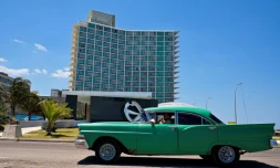 Un berline américaine passe devant l'hôtel Riviera qui a abrité un casino jusqu'à la révolution castriste de 1959, à La Havane, le 14 avril 2025