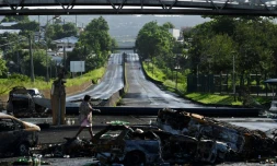 Des carcasses de voitures brûlées à cÎté d'un barrage sur une route au Lamentin, en Martinique, le 30 novembre 2021