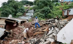 Des habitants récupÚrent les restes de ce qui était l'église méthodiste d'Afrique du Sud à Clermont, prÚs de Durban, le 13 avril 2022, aprÚs les fortes pluies qui ont tué quatre enfants de la région ( AFP / PHILL MAGAKOE )