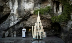 Cette photo prise le 9 avril 2020 montre le recteur Olivier Ribadeau Dumas lors d?une petite messe à la Grotte de Massabielle, dans le Sanctuaire notre-Dame de Lourdes, alors que le lieu de pÚlerinage catholique était fermé au public en raison du coronavirus