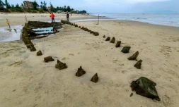 Une épave vieille de plusieurs siÚcles, découverte aprÚs le passage du typhon Kalmaegi, sur une plage au large de Hoi An, dans le centre du Vietnam, le 10 novembre 2025 ( AFP / Tam Xuan )