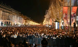 Des personnes se rassemblent sur l'avenue des Champs-Elysées pour les célébrations du Nouvel An à Paris, le 31 décembre 2023