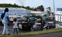 Un habitant dégage une route à Nouméa, le 15 mai 2024