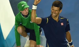 Novak Djokovic lève le bras après avoir éliminé le Japonais Kei Nishikori en quarts de finale à l'Open d'Australie, le 26 janvier 2016 à Melbourne
