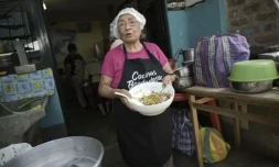 Isabel Santos prépare un plat avec des épluchures de légumes pour tirer le meilleur parti de la nourriture dans une soupe populaire à Lima, le 5 avril 2024 ( AFP / ERNESTO BENAVIDES )