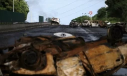 Des véhicules incendiés gisent sur une route menant à Nouméa, dans le territoire français de Nouvelle-Calédonie, le 20 mai 2024 ( AFP / Theo Rouby )